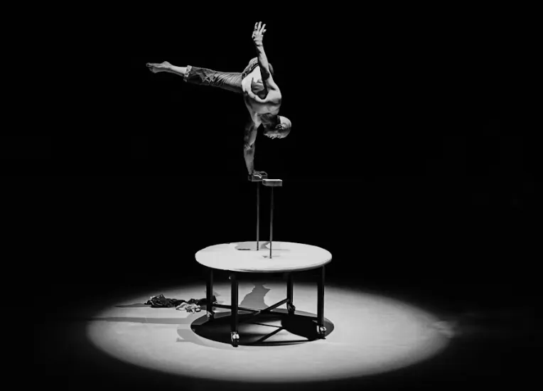 Cirque du Soleil performer in an acrobatic pose on stage