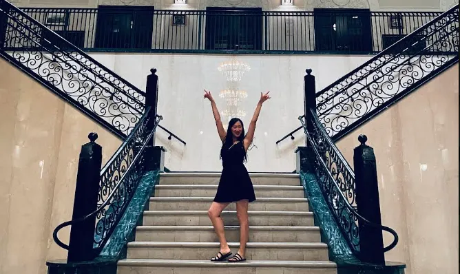 Karin standing on a grand staircase
